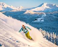 a man riding a snowboard down a snow covered slope