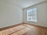 A room with a window and wooden flooring.