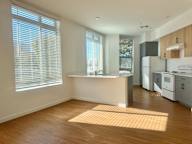 A kitchen with white appliances and wooden cabinets.