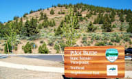 a sign for the pilot butte state scenic viewpoint on the side of a mountain