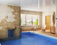 a swimming pool with a stone wall and a blue pool