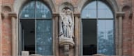 a statue on the side of a brick building
