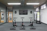 a group of exercise bikes in a gym with a tv