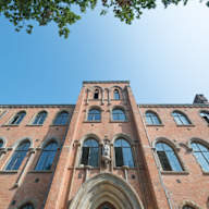 the front of a brick building with the sky in the background