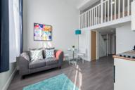 a living room with a couch and a staircase