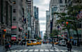 A busy city street with pedestrians crossing the road.