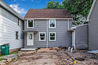 A grey house with a white door and windows.