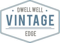 A blue and white logo that says Dwell Well Vintage Edge.