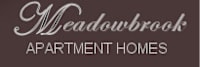 A brown sign that says Meadowbrook Apartment Homes.