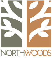 A logo with the words "North Woods" and a stylized tree design.