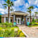A house with a front yard featuring a palm tree and a brick pathway leading to the entrance.