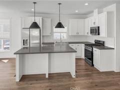 Floor Plan  A kitchen with white cabinets and a black island.