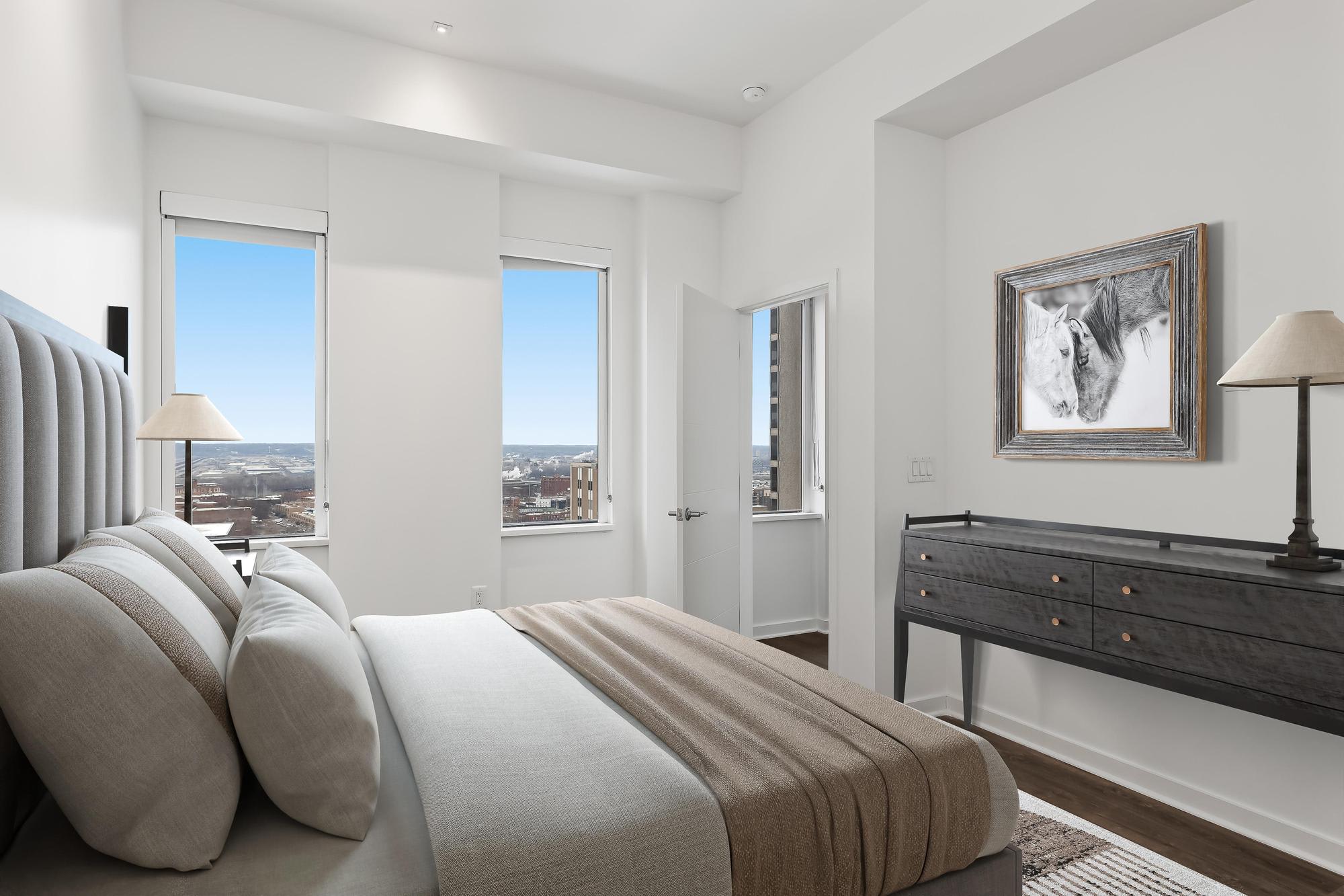 Staged bedroom at Sky on Main with a large bed, nightstands, and wall art