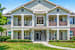 A two-story house with a front porch and a balcony on the second floor.