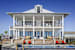 A white house with a pool in front.