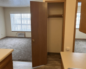 an empty kitchen and living room with an open door