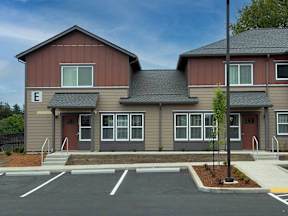 A two-story building with a parking lot in front.