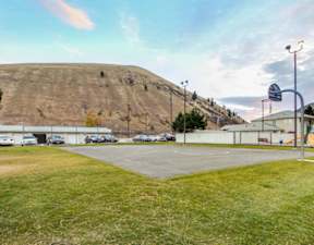A parking lot with a large hill in the background.
