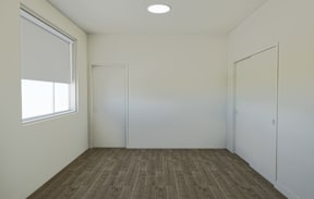 A room with a brown carpet and white walls.