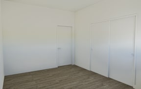 A room with two doors and carpeted flooring.