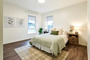 a bedroom with a bed and two windows