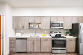 a kitchen with wooden cabinets and stainless steel appliances