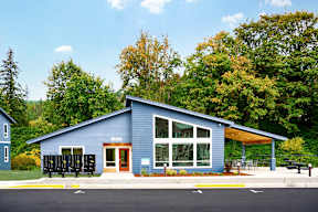 the exterior of a blue house with a large window and a porch