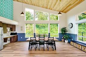 a dining room with a table and chairs and a large window