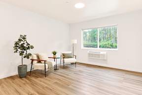 a living room with a large window and wooden floors