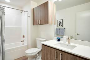 A white toilet sits next to a white sink in a bathroom.