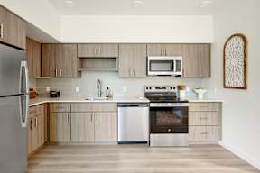 A modern kitchen with a refrigerator, oven, and microwave.