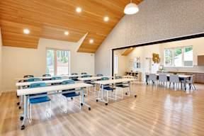 A room with tables and chairs and a window.