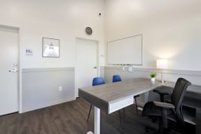 a room with a desk and chairs and a mirror