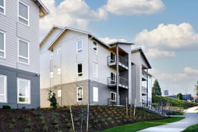 a row of three story apartments with balconies and a sidewalk