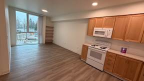 A kitchen with a white stove and wooden cabinets.