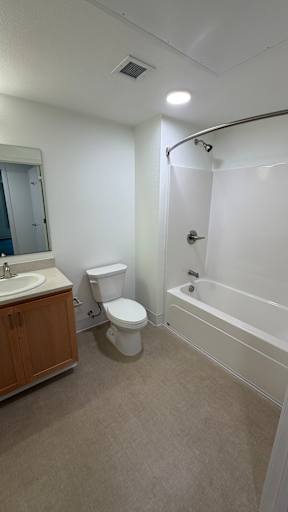 A white toilet sits in a bathroom next to a sink and a bathtub.