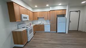 A kitchen with wooden cabinets and white appliances.