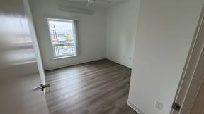 A room with a window and a wooden floor.