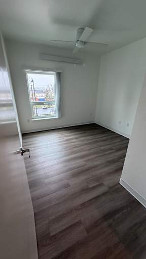 A room with a window and a ceiling fan.