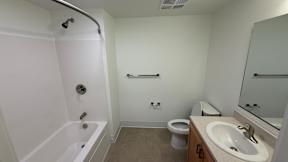 A white bathroom with a toilet, sink, and bathtub.