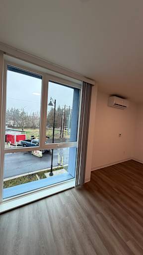 A room with a large window overlooking a parking lot.