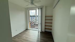A room with a sliding glass door leading to a balcony.