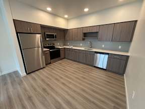 A modern kitchen with wooden cabinets and stainless steel appliances.