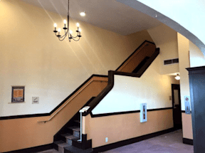 A staircase with a chandelier hanging above it.