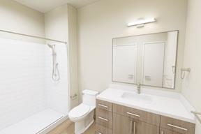 A white bathroom with a toilet, sink, and mirror.