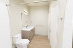 A white bathroom with a toilet, sink, and mirror.