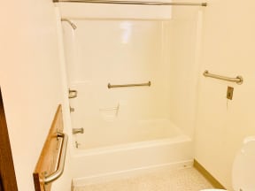 a bathroom with a bathtub and a toilet in a hotel room