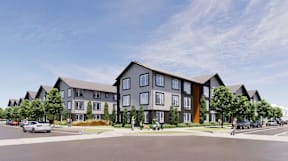 A modern apartment complex with a parking lot in front.