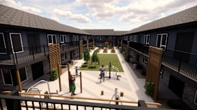 A courtyard with a playground and a woman walking a dog.
