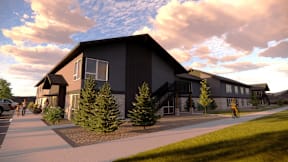 A modern building with a grey exterior and a few trees in front.